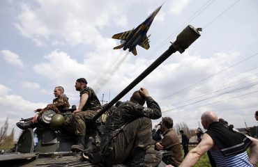 A fighter jet flies above Ukrainian soldiers in Kramatorsk